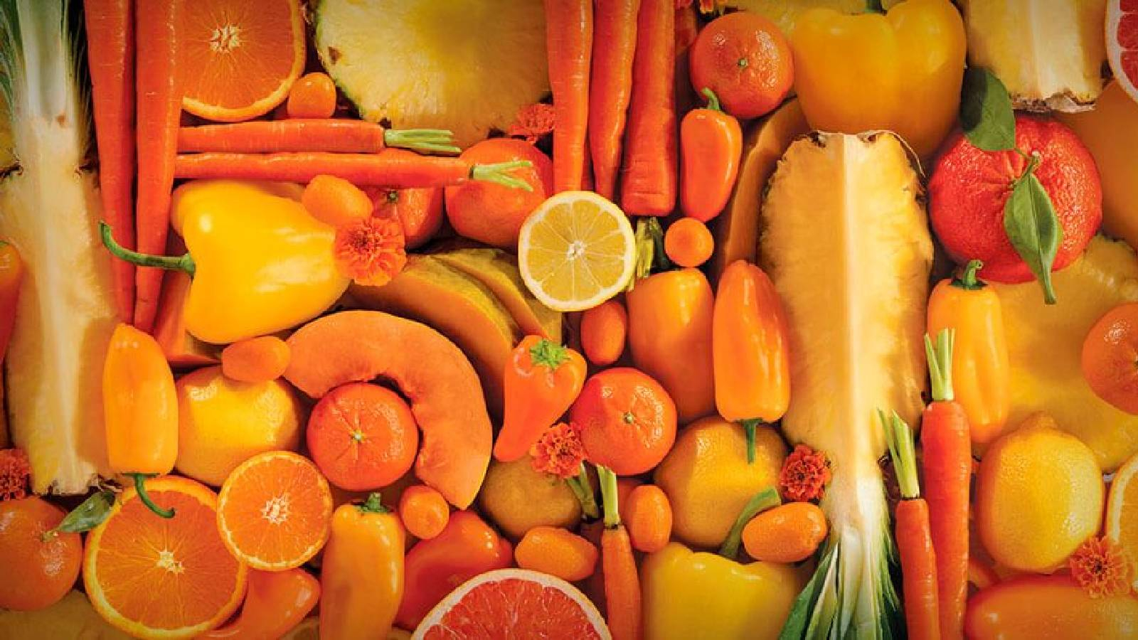 مجموعة كبيرة من الفواكه الصفراء والبرتقالية كالتفاح الأصفر، والجزر والاناناس والمشمش، والبرتقال، والليمون، والمانجو